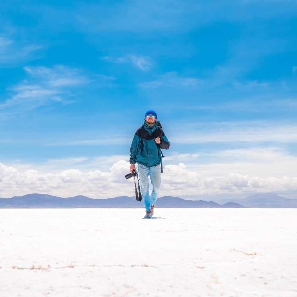 Photographer in spacious sunshine Salar de Uyuni